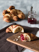 croissant mit marmelade von vorne fotografiert mit marmelade im hintergrund auf hellem untergrun.jpg