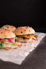 vegane burger mit kichererbsen hokkaido patty auf backpapier und schwarzem hintergrund 45 grad f.jpg