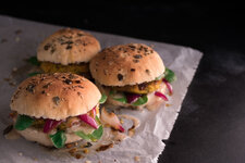 vegane burger mit kichererbsen hokkaido patty auf backpapier und schwarzem hintergrund 45 grad f.jpg